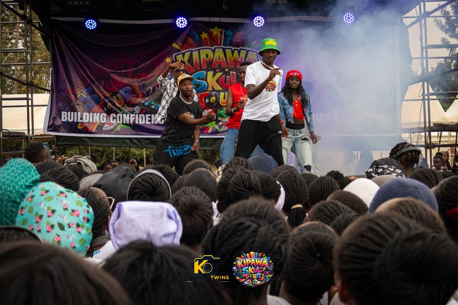 Dancers performing on the Kipawa Skul Tour stage through stage smoke in front of a packed student crowd