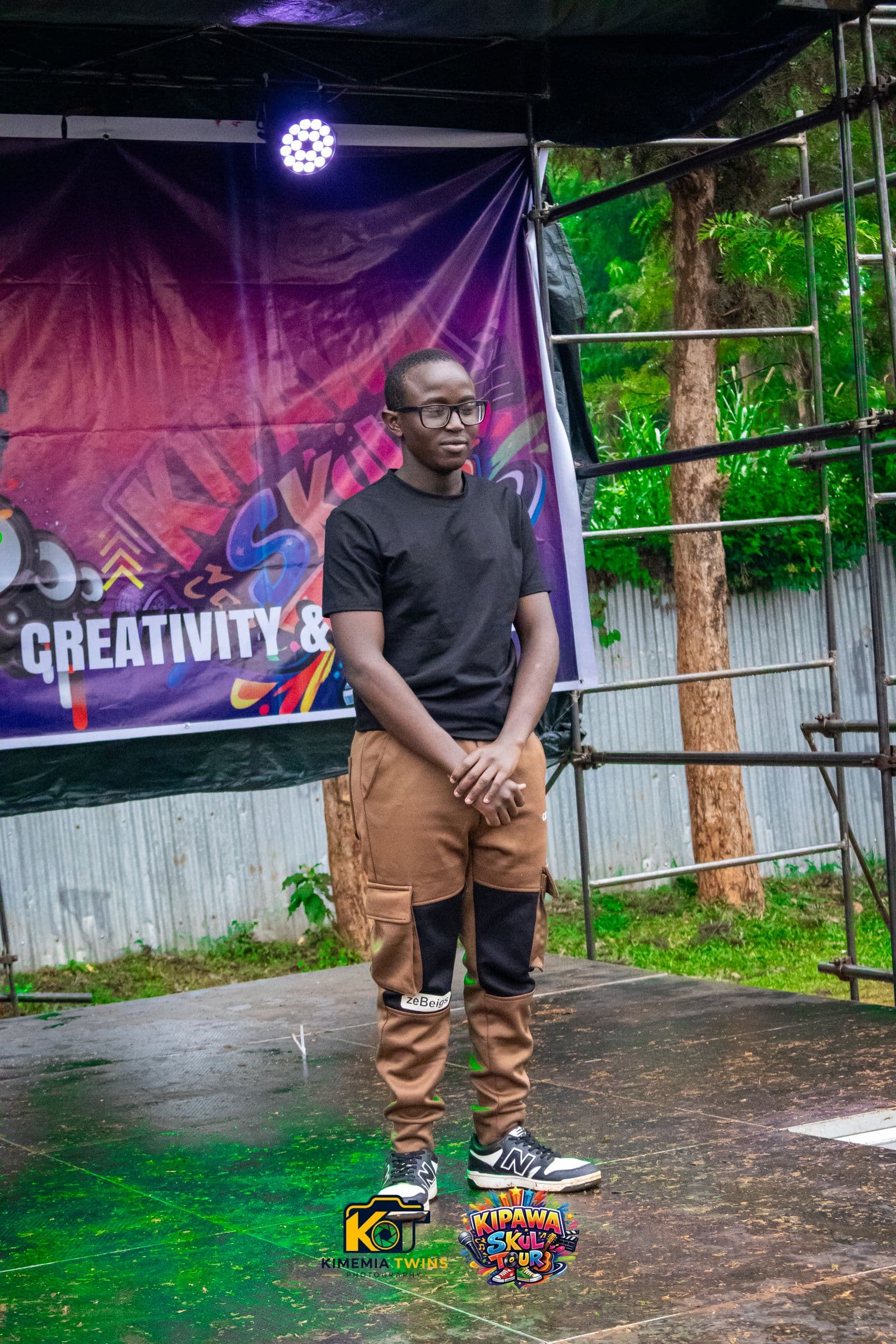 Student performer on the Kipawa Skul Tour stage in front of the branded backdrop