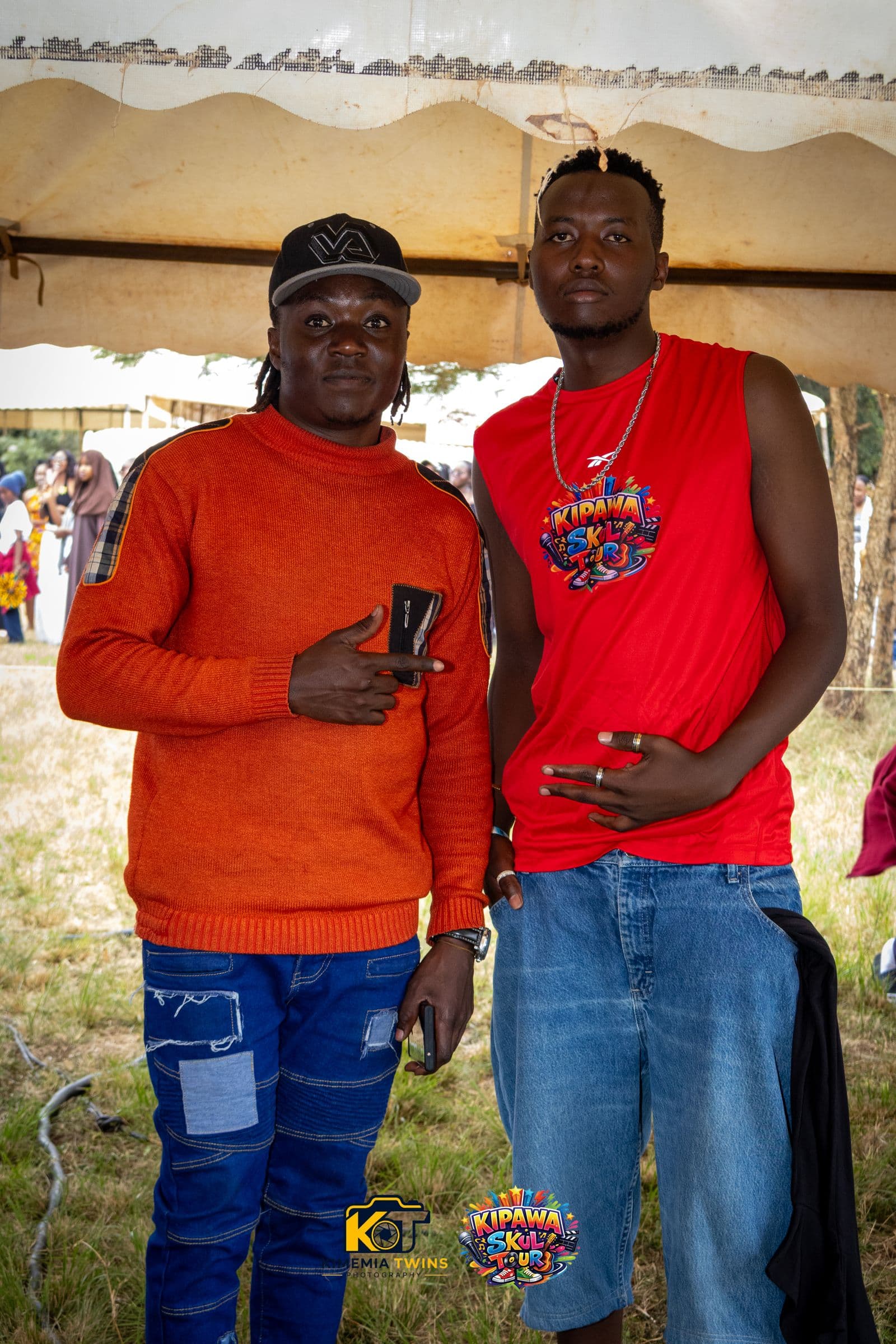 Two attendees in Kipawa Skul Tour merchandise at a school event