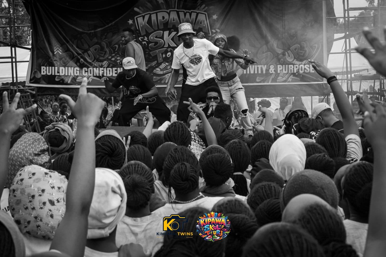 Crowd of students with raised hands in front of the stage, black and white photo
